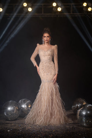 Woman in a long, beaded gown with a feathered train.