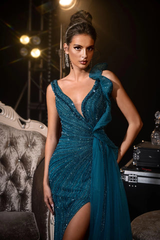 Woman in teal gown with high slit.