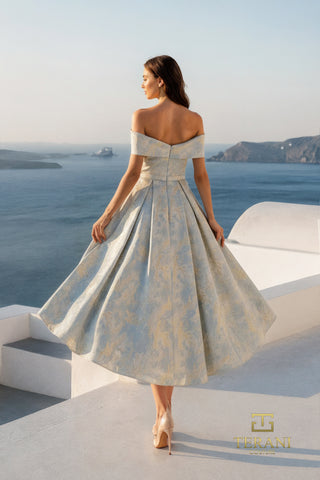Woman in off-shoulder dress overlooking ocean.