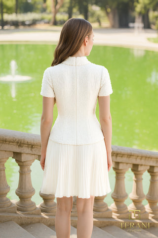 Woman in white dress standing near a pond.