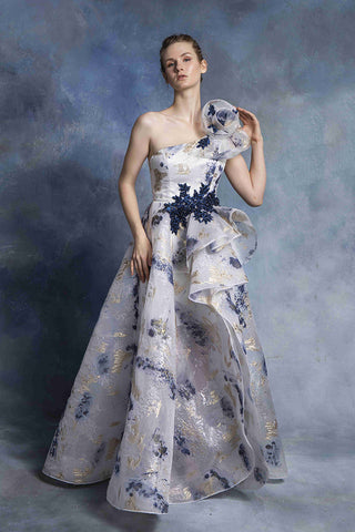 Woman in a one-shoulder floral print gown.