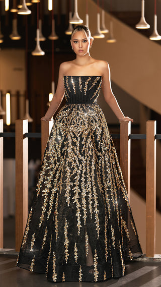 Woman in a black and gold sequined gown.