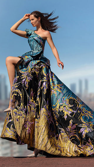 Woman in a patterned, flowing gown against a city skyline.