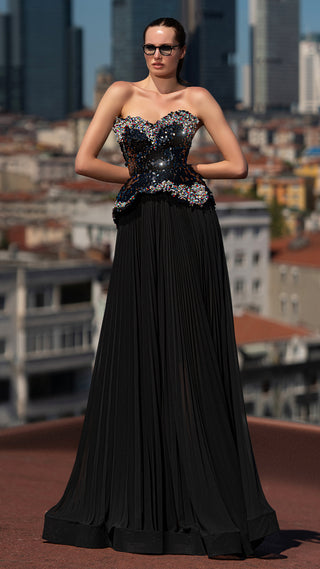 Woman in black evening gown and sunglasses.