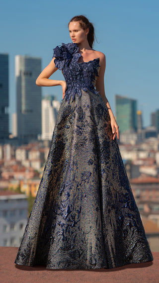 Woman in blue floral gown with cityscape background.
