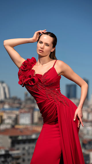 Woman in red dress posing outdoors.