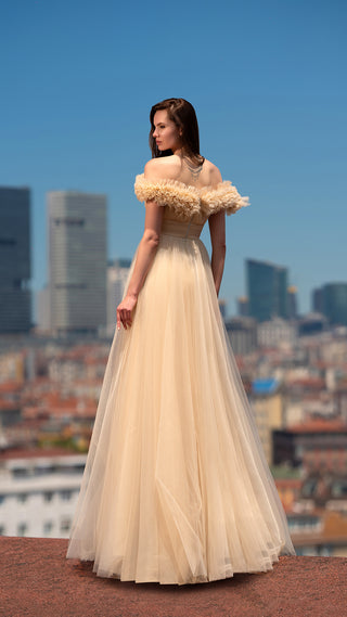 Woman in gown overlooking cityscape.