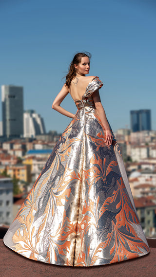 Woman in a shimmering gown, cityscape background.