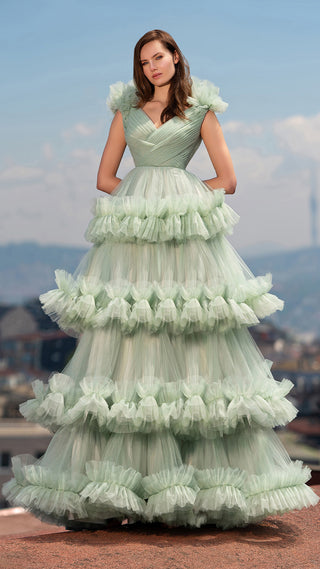 Woman in a tiered, ruffled, mint green gown.