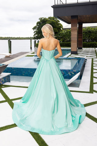 Woman in mint green formal gown by pool