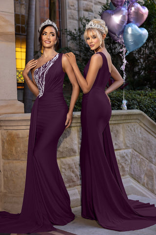 Two women in aubergine gowns with balloons.