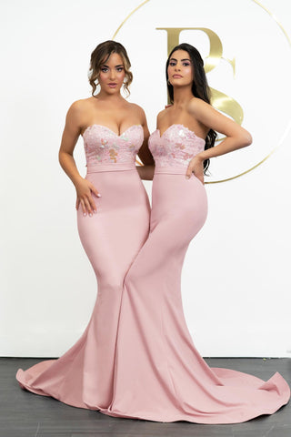 Two women in blush pink strapless gowns