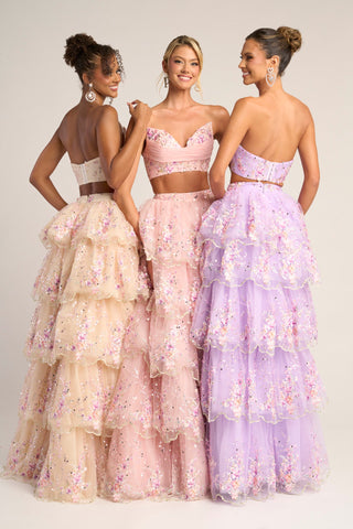 Three women in cream, pink, and lilac tiered formal gowns.