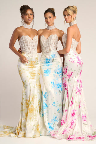 Three women in yellow, blue, and pink floral gowns.