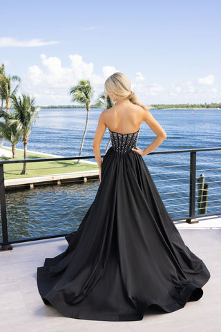 Woman in black formal gown overlooking water