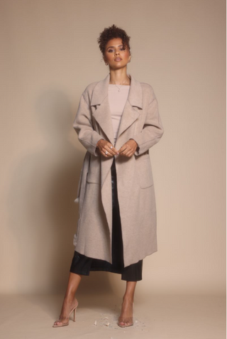 Woman in beige coat, screenshot Oct 30, 2025.