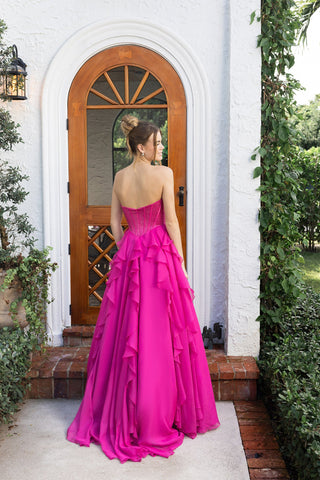 Fuchsia gown XO174 in front of wooden door.