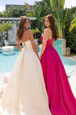 Two women in XO187 Champagne & Fuchsia gowns by pool