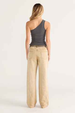 Chelsea wearing one-shoulder top and tan pants