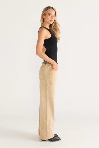 Chloe in black tank top and beige pants