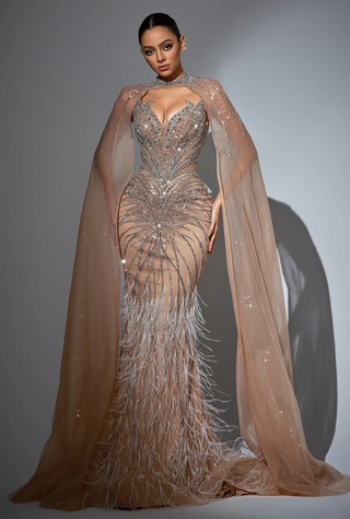 Woman in a beaded gown with cape and feathered skirt.