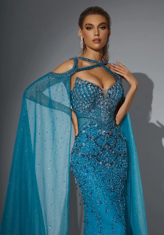 Woman in a sparkling blue gown with cape.