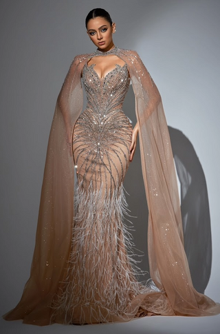 Woman in a beaded gown with cape and feathered skirt.