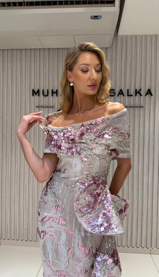 Woman in an off-shoulder, sequined gown.