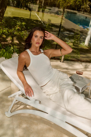 Woman in white outfit relaxing on a lounger