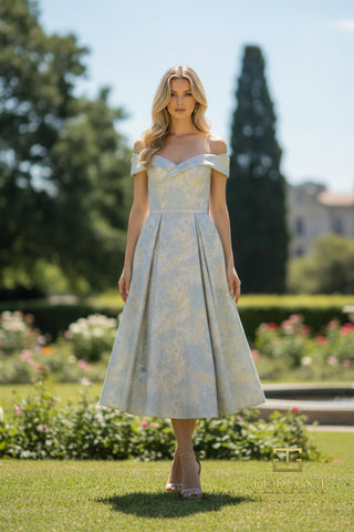 Woman in off-the-shoulder dress standing on grass.