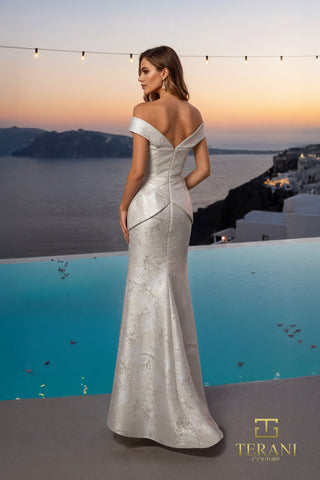 Woman in silver evening gown overlooking water.