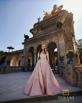 Woman in pink Terani Couture gown in front of ornate building