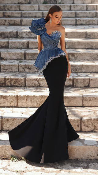 Woman in blue and black formal dress on steps.