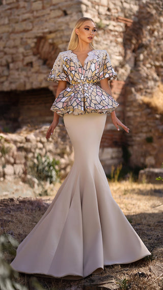 Woman in a formal gown with a patterned bodice and fishtail skirt.