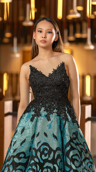 Woman in a black and teal gown.