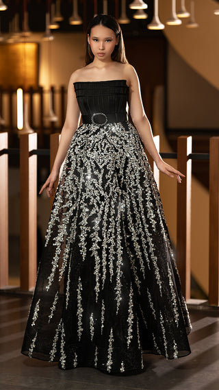 Woman in black strapless gown with silver embellishments.