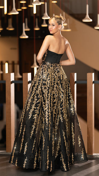 Woman in black and gold gown.