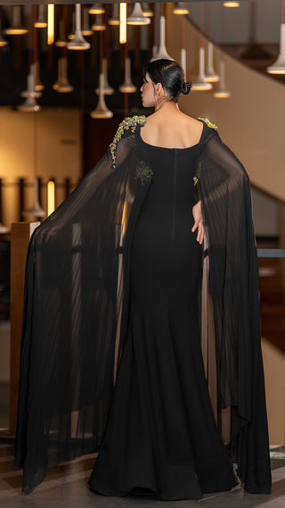 Woman in a black gown with long, flowing sleeves.