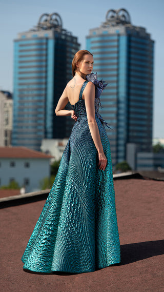 Woman in teal gown standing on rooftop.