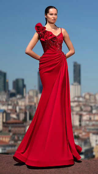 Woman in red formal dress with cityscape background.