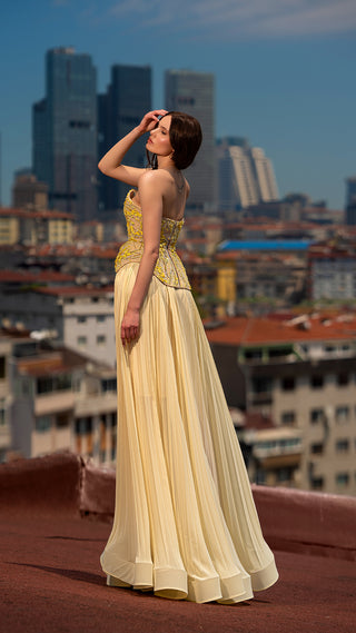 Woman in yellow dress on rooftop, city background.