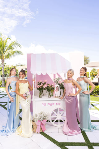 Women in gowns by flower cart