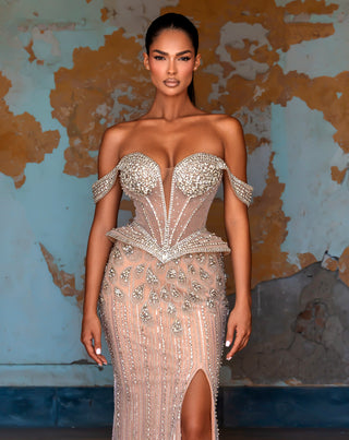 Woman in embellished strapless gown with high slit.