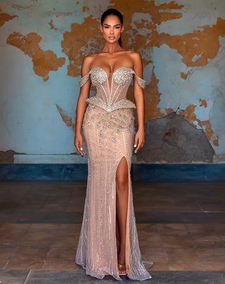Woman in beaded off-shoulder gown with leg slit.