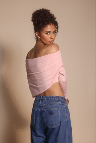 Woman in pink off-shoulder top and jeans, screenshot from Oct 30, 2025.