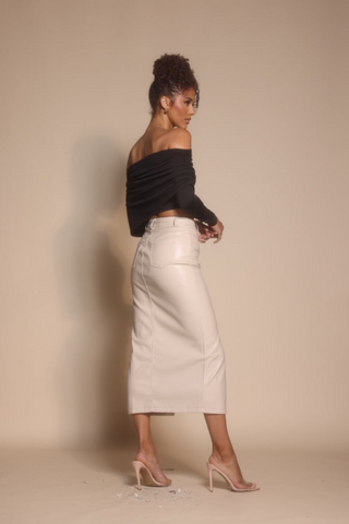 Woman in black top and cream skirt, screenshot from Oct 30, 2025.