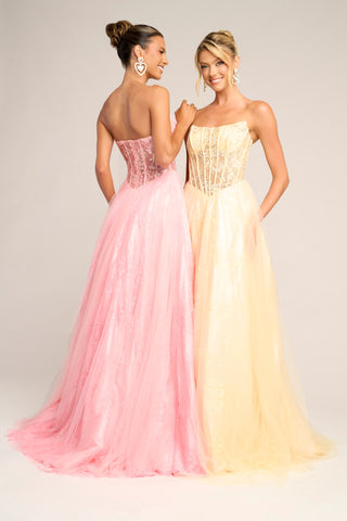 Two women in yellow and pink formal gowns.