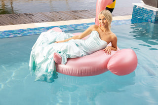 Woman in light blue dress on pink flamingo float