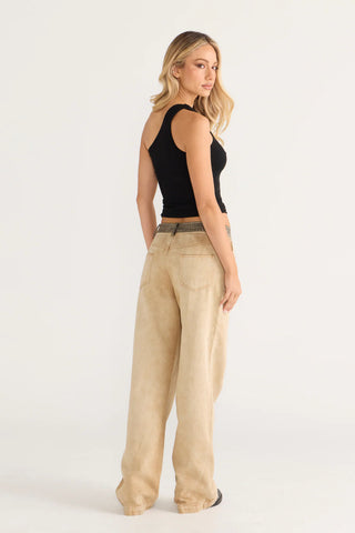 Cara in black top and tan pants