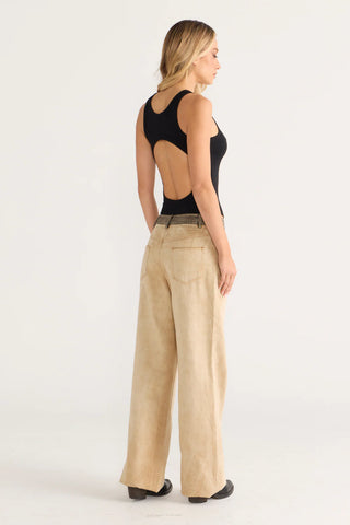 Chloe in black bodysuit and tan pants